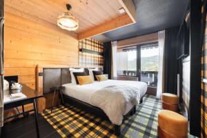a hotel room with a bed and a desk and window at Mamie Megève in Megève