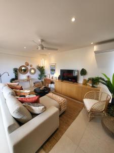 - un salon avec un canapé et une télévision dans l'établissement Les Hauteurs de la Baie, à Nouméa