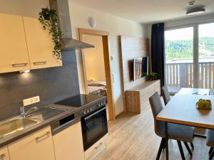 a kitchen with a sink and a table with a counter top at Haus Tauernblick Katschberg by AlpenTravel in Katschberghöhe