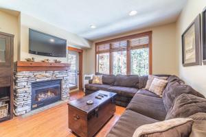 a living room with a couch and a fireplace at 506 Village Condo Steps to Gondola in Mammoth Lakes