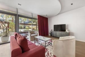 a living room with a red couch and a tv at City Walk, Al Wasl, Jumeirah - Mint Stay in Dubai