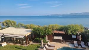 a house with a pool and a view of the water at Enalio Suites in Lechaio