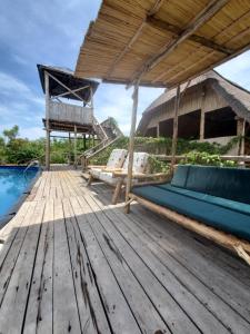 a wooden deck with a couch on top of a house at NKUNDWA NILE VIEW LODGE in Wanseko