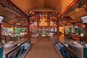 an open lobby of a resort with wooden beams at Ananta Spa & Resort, Pushkar in Pushkar