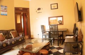 ein Wohnzimmer mit einem Sofa und einem Tisch in der Unterkunft The Berroni Residence in Kampala
