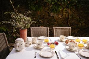 une table avec des tasses et des assiettes de nourriture dans l'établissement Casa Muíñovedro, à Chantada