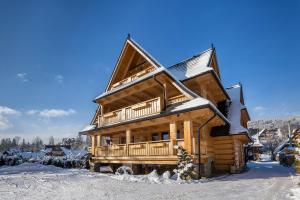 a log cabin in the snow with snow at Aparthotel Bambi in Zakopane