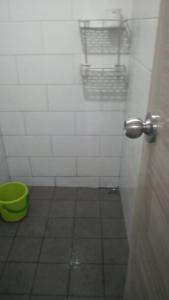 La salle de bains est pourvue d'une porte avec un seau vert. dans l'établissement tmy, à Sleman