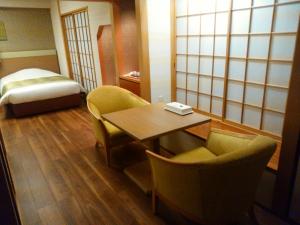 徳島市にあるJRホテルクレメント徳島のテーブル、椅子、ベッドが備わる客室です。