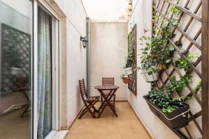 einen Balkon mit einem Tisch, Stühlen und Pflanzen in der Unterkunft CastelPlace beach con plaza de Garage incluida, free parking in Alicante