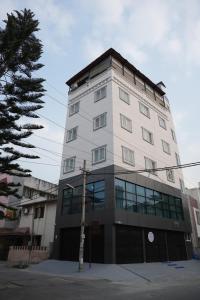 a tall white building with windows on a street at Zylo Indiranagar in Bangalore