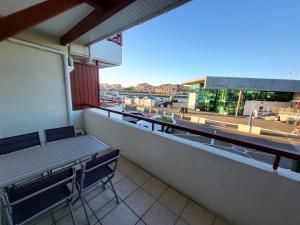 einen Balkon mit Bänken und Straßenblick in der Unterkunft Résidence l'ACCALMIE- Appartement pour 4 personnes proche du port de pêche in Capbreton