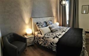 a bedroom with a bed and a chair at Appartement sous les remparts in Carcassonne