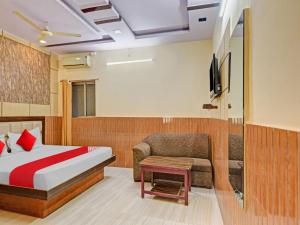 1 dormitorio con cama, sofá y TV en OYO Flagship 81128 Hotel Preet Palace, en Ranchi