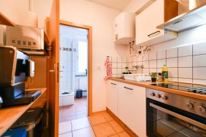 a kitchen with white cabinets and a stove top oven at Fürst-Pückler-Apartment_bis 6 Personen_Waschmaschine_Küche_2x Parkplätze_Terrasse_Netflix in Cottbus