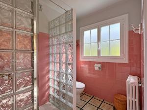 uma casa de banho com um WC e uma porta de duche em vidro. em ETXEALE em Valcarlos