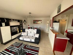 ein Wohnzimmer mit einem Bett und eine Küche in der Unterkunft Résidence l'ACCALMIE- Appartement pour 4 personnes proche du port de pêche in Capbreton