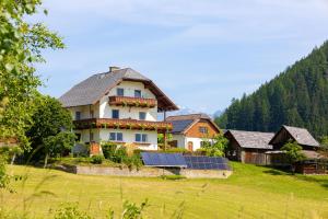 a house with a solar panel in a field at Appartement Annis Murtalblick in Sankt Margarethen im Lungau