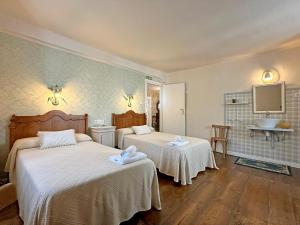 1 dormitorio con 2 camas y TV en la pared en ETXEALE en Valcarlos