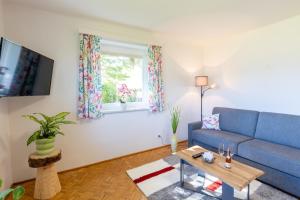 ein Wohnzimmer mit einem blauen Sofa und einem Tisch in der Unterkunft Appartement Annis Murtalblick in Sankt Margarethen im Lungau