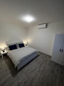 Dormitorio blanco con cama y pared blanca en The Houses - Chata u sjezdovky 1 en Velké Meziříčí
