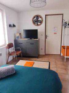 1 dormitorio con 1 cama, TV y mesa en Little World - Saint-Julien-les-villas, en Saint-Julien-les-Villas