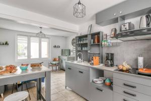 cocina con armarios grises y encimera en Little World - Saint-Julien-les-villas, en Saint-Julien-les-Villas