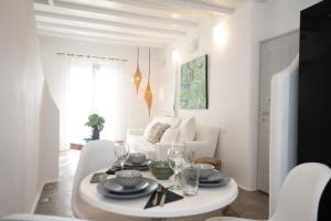 un soggiorno bianco con tavolo e sedie bianchi di House of Nikol - Cycladic Sensation ad Áno Merá