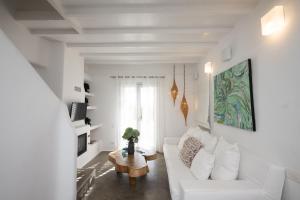 un soggiorno bianco con divano bianco e tavolo di House of Nikol - Cycladic Sensation ad Áno Merá
