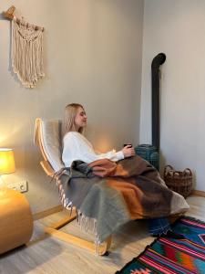 リヴィウにあるModern apartment on Lemkivskaの毛布の下に椅子に座る女