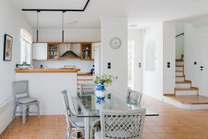 Iliana Exclusive Villa - Private Pool - Walking Distance To Beach في بورتوخيلي: مطبخ وغرفة طعام مع طاولة وكراسي زجاجية