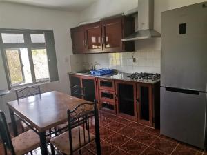 a kitchen with wooden cabinets and a table and a refrigerator at Villa TORARICA in Pointe aux Biches