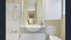a bathroom with a sink and a toilet and a shower at Knightsbridge Apartments in Melbourne