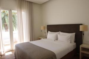 a hotel room with a large bed and a large window at Hostal Spa Empúries in L'Escala