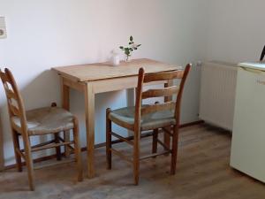 einem Holztisch mit zwei Stühlen und einer Vase darauf in der Unterkunft Haus Scheibenhardt 