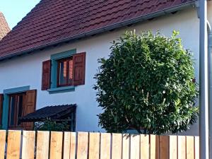 ein weißes Haus mit einem Baum neben einem Zaun in der Unterkunft Haus Scheibenhardt 