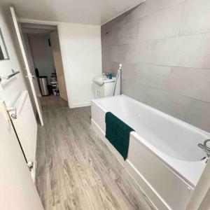 a bathroom with a white tub and a green towel at London Apartment - Near Kings Cross St Pancreas! in London