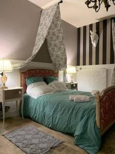 1 dormitorio con 1 cama grande con dosel en Le Grand Faubourg, en Lorris