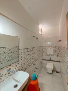 Baño blanco con lavabo y aseo en HOTEL PANETAR PALACE, en Ahmedabad