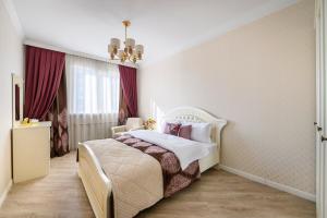 1 dormitorio con cama blanca y cortinas rojas en КАК Дома - квартира на 6 человек, en Almaty