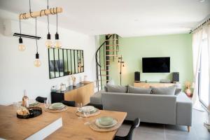 ein Wohnzimmer mit einem Sofa und einem Tisch in der Unterkunft Les Brézines - Maison Clim Terrasse Plancha au coeur de Mus 3 Etoiles - MaisoncarréeConciergerie in Mus