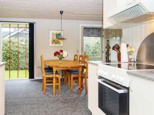 a kitchen with a wooden table and a dining room at 4 person holiday home in F rvang in Fårvang