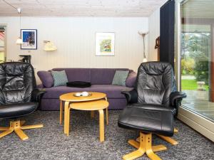 a living room with a purple couch and two chairs at 4 person holiday home in F rvang in Fårvang
