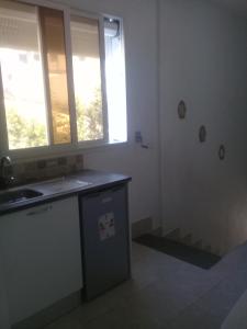 a kitchen with a sink and two windows at Maison a louer a la grotte de Bizerte in Dar el Koudia