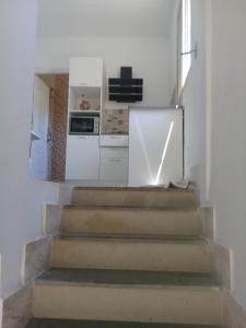 a staircase in a kitchen with white walls and white appliances at Maison a louer a la grotte de Bizerte in Dar el Koudia