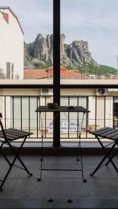 a table and two chairs in front of a window at ORIENTE SUITE APARTMENT in Kalabaka