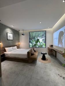 a bedroom with a bed and a large window at KIN WANDER - Tân Phong in Ho Chi Minh City