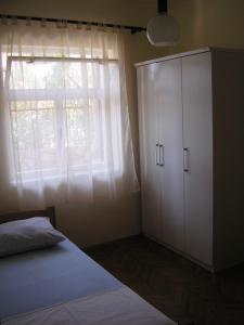 a bedroom with a bed and a dresser and a window at Apartments Ajka in Tisno
