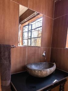 Un baño con un gran lavabo de piedra sobre una encimera. en Latona Guest House, en Johannesburgo