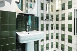 Kraft Hotel في باريس: حمام مع حوض ومرآة